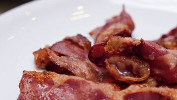 A plate of cooked bacon strips.