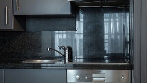 A modern kitchen with a stainless steel dishwasher, a built-in oven, and a range hood. - Amosa Liège City Centre Apart Gerardrie 23 (Liege)