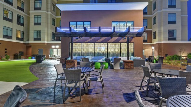 A hotel courtyard with outdoor seating, a covered area, and a well-maintained lawn. - Homewood Suites by Hilton Savannah-North/Airport (Savannah)
