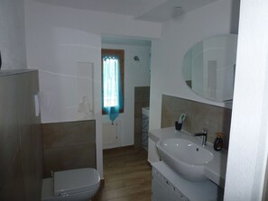 Un baño con inodoro, lavamanos y espejo.