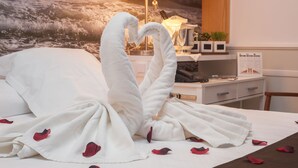 A hotel room with a bed, a nightstand, a lamp, and a wall mural. - Hotel Ribes Roges (Vilanova I la Geltru)