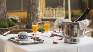 A breakfast setup with a tray, two glasses of orange juice, a teapot, and a cup with a blue pattern. - Hotel Ribes Roges (Vilanova I la Geltru)