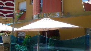 A hotel with a yellow facade, multiple balconies with flower planters, and a sign reading "HERBES ROGES". - Hotel Ribes Roges (Vilanova I la Geltru)