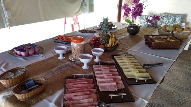 Una mesa de buffet con diversos alimentos, entre ellos carnes, frutas y salsas.
