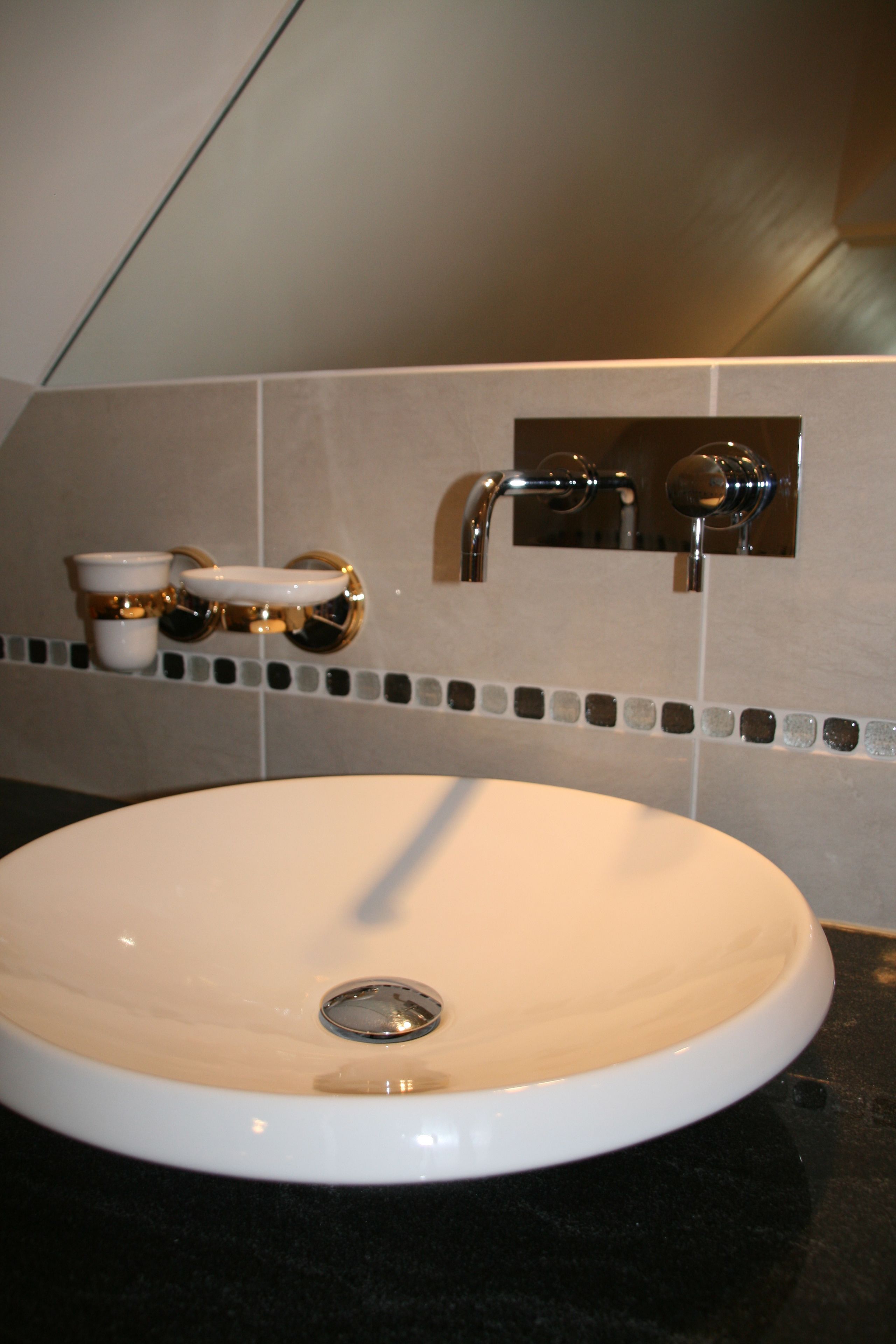 Une salle de bain avec un lavabo blanc, un miroir et un porte-serviettes.