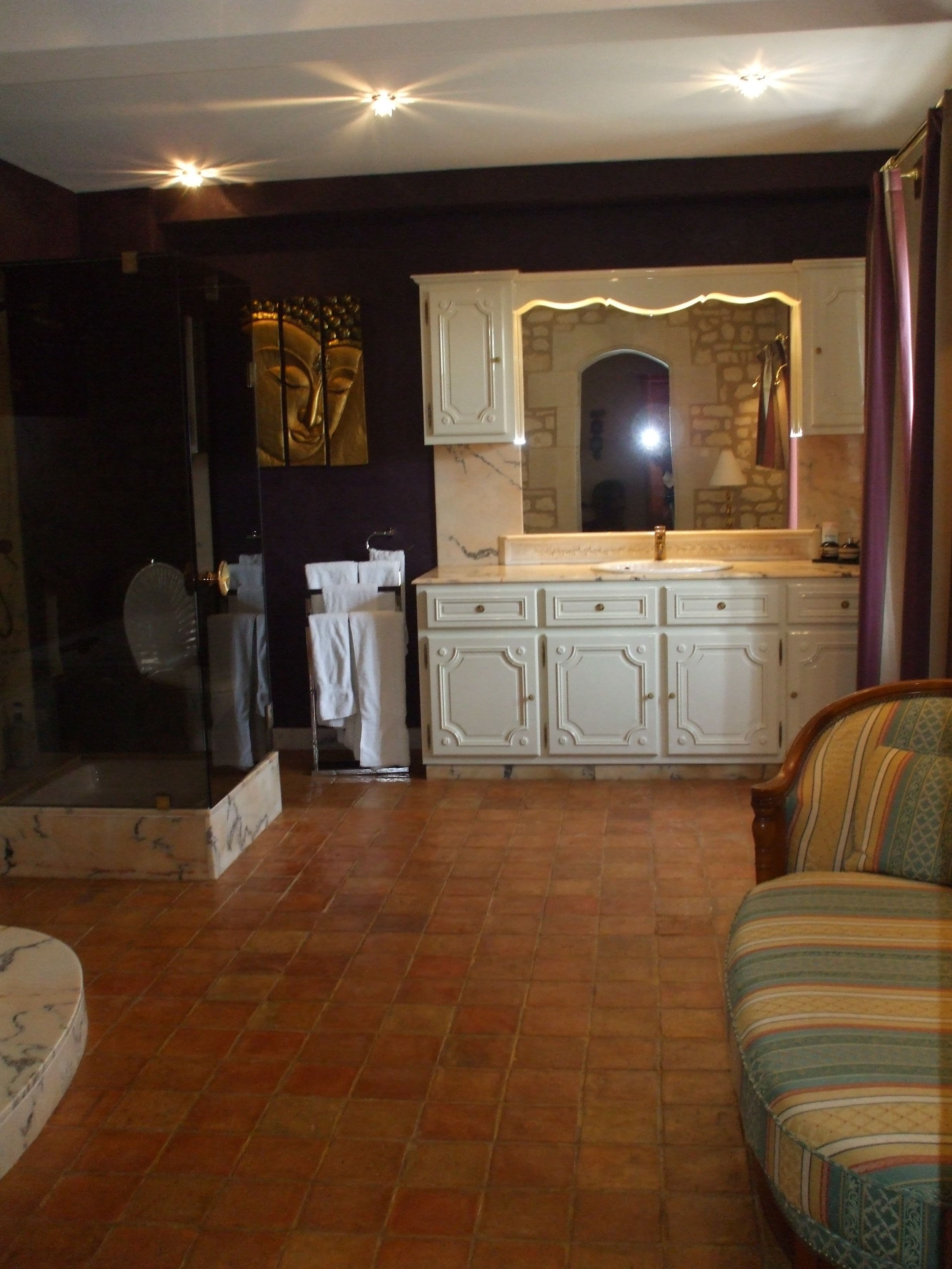 A spacious living area with a large window, a fireplace, and a sofa.