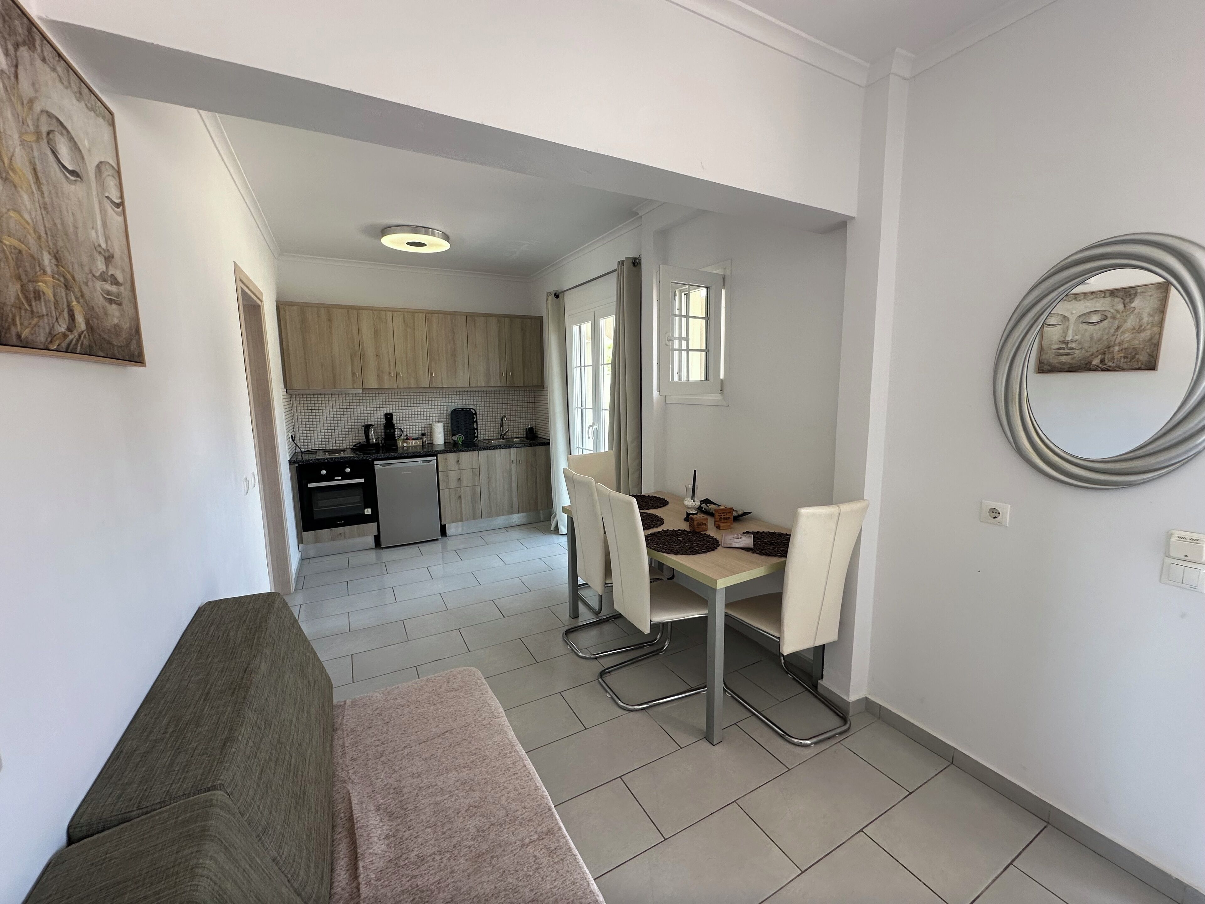 Un espacio habitable compacto con kitchenette, comedor y sofá.