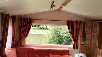 A cozy room with a sofa, a small table, and a window with curtains.