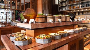A buffet with various dishes and a decorative centerpiece. - Hilton Goa Resort Candolim (Candolim)