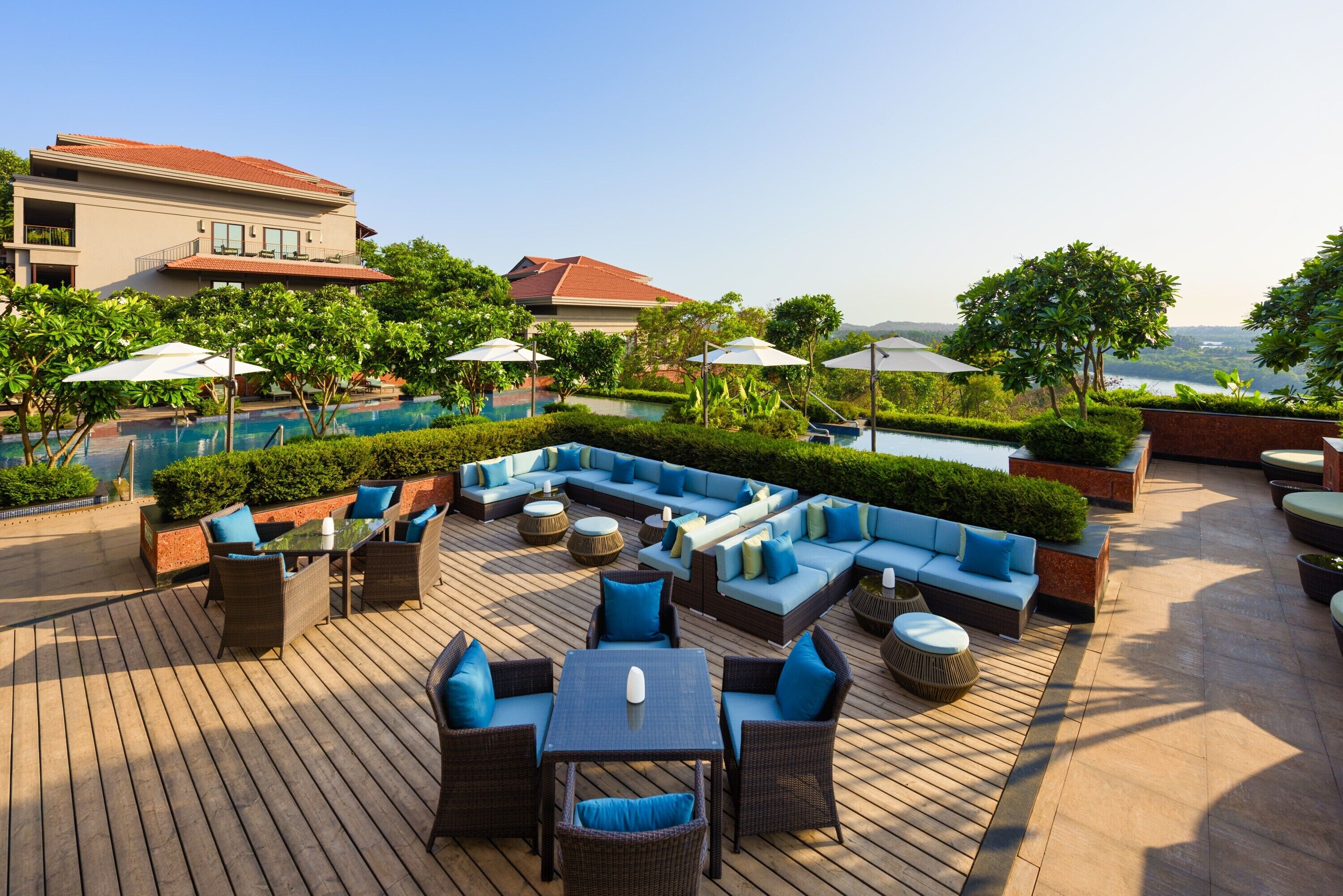 A rooftop pool area with outdoor seating and a view of the surrounding landscape.