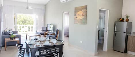 A modern apartment with a dining area, kitchen, and living space.
