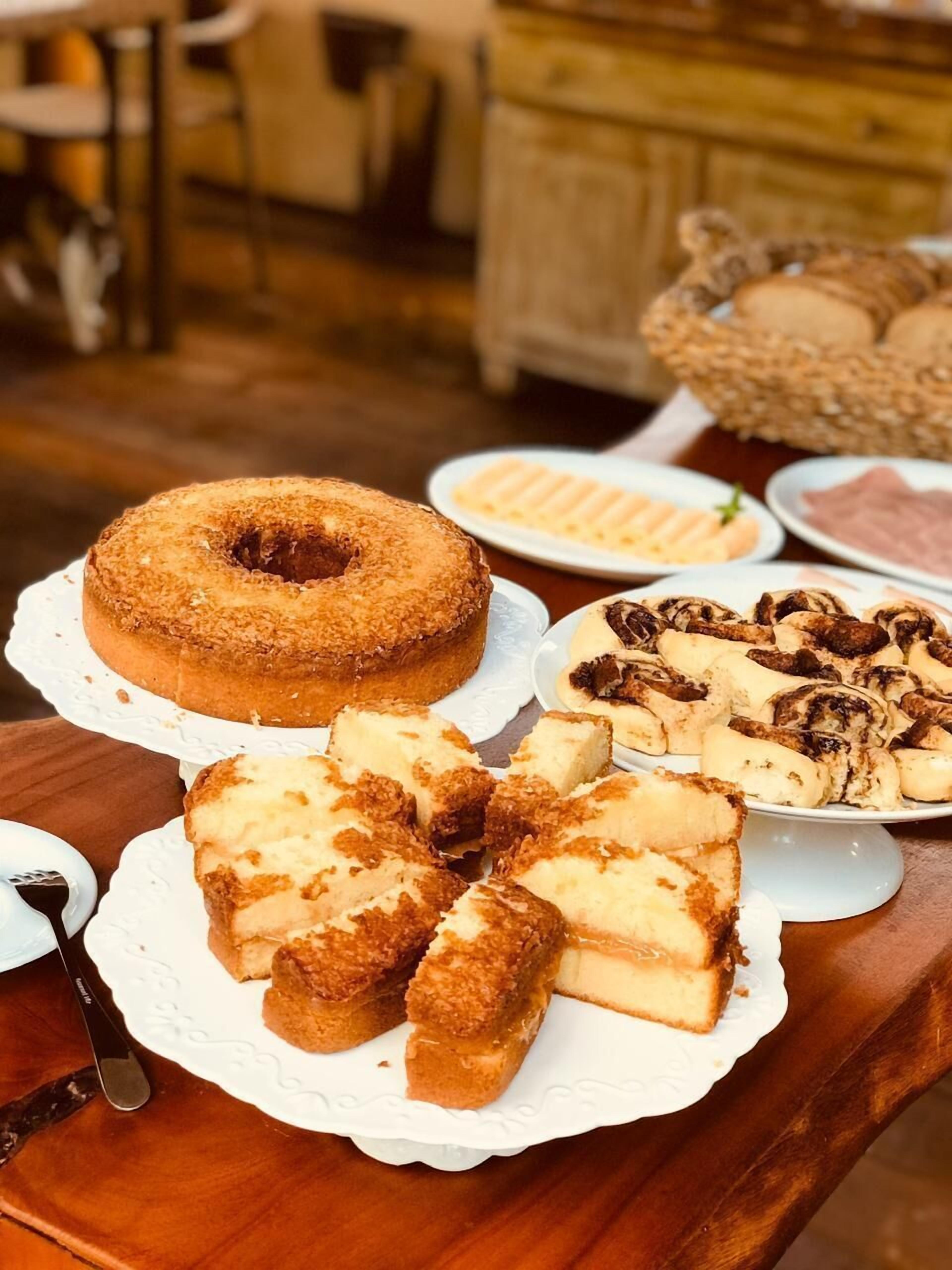 Una mesa con diversos postres, incluyendo un pastel Bundt, porciones de pastel de queso y otras pastelerías.