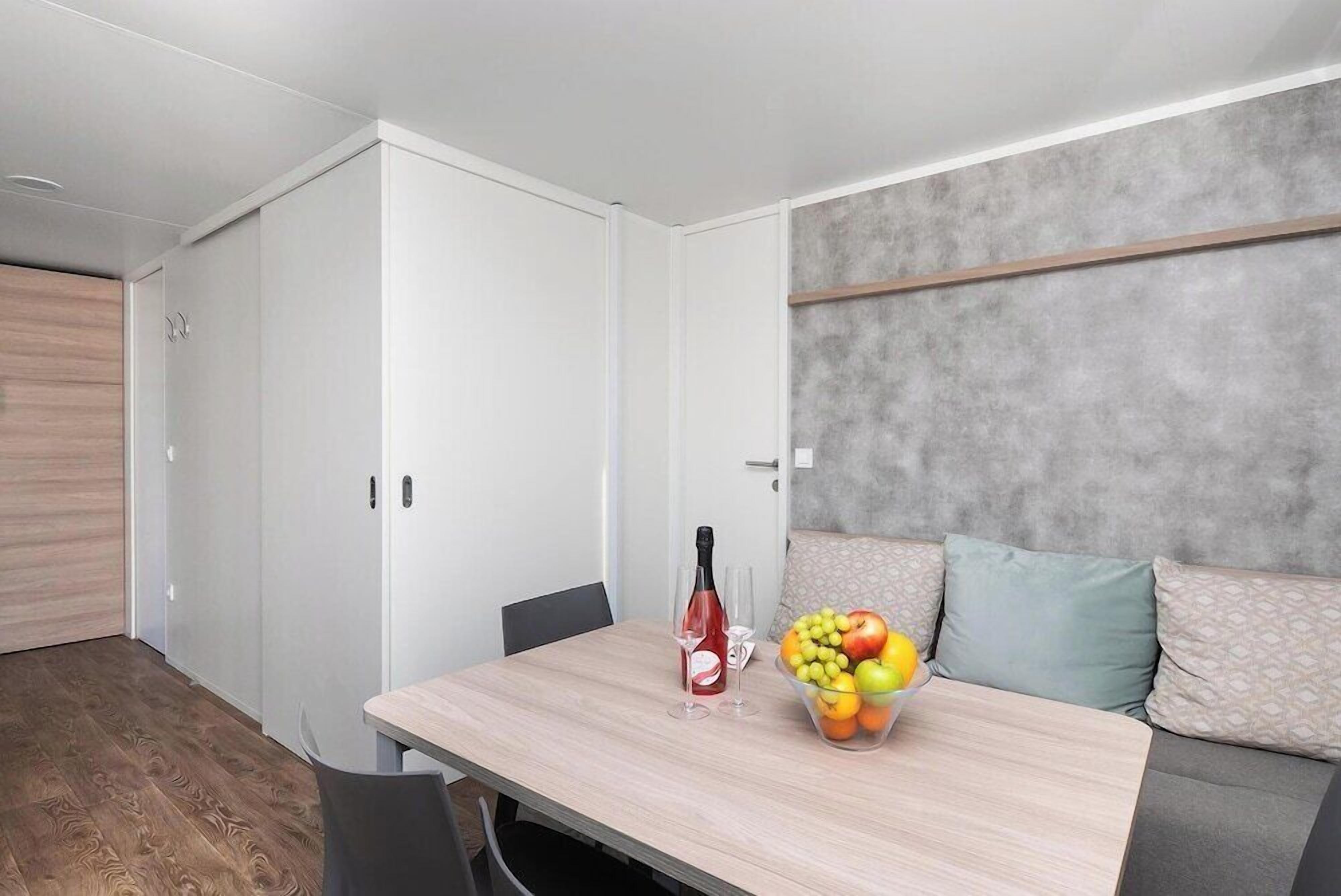Ein modernes Zimmer mit Esstisch, einer Couch und einem Kleiderschrank.
