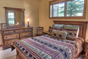 A bedroom with a large bed, a dresser, a chair, and a window with a view of trees. - 120 Rachel Lane Private Home with Hot Tub (Breckenridge)
