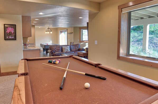 A pool table with a ball and cues, a sofa, and a window with a view of greenery. - 120 Rachel Lane Private Home with Hot Tub (Breckenridge)