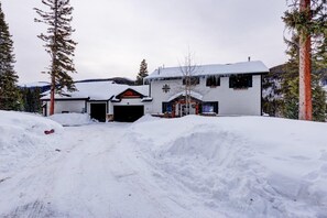 A snow-covered building with a garage and a small porch area.