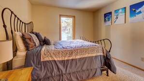 A bedroom with a bed, a nightstand, a window, and three wall-mounted pictures. - 72 Clubhouse Rd Private Home with Hot Tub (Breckenridge)