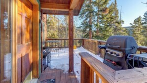 A wooden deck with a barbecue grill, outdoor seating, and a view of trees. - 72 Clubhouse Rd Private Home with Hot Tub (Breckenridge)