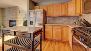 A modern kitchen with wooden cabinets, a stainless steel refrigerator, a built-in oven, and a gas stove. - 72 Clubhouse Rd Private Home with Hot Tub (Breckenridge)