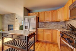 A modern kitchen with wooden cabinets, a stainless steel refrigerator, a built-in oven, and a gas stove. - 72 Clubhouse Rd Private Home with Hot Tub (Breckenridge)