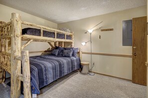Ein Stockbett mit blauen Mustern, eine Nachttischlampe und eine Holztür.