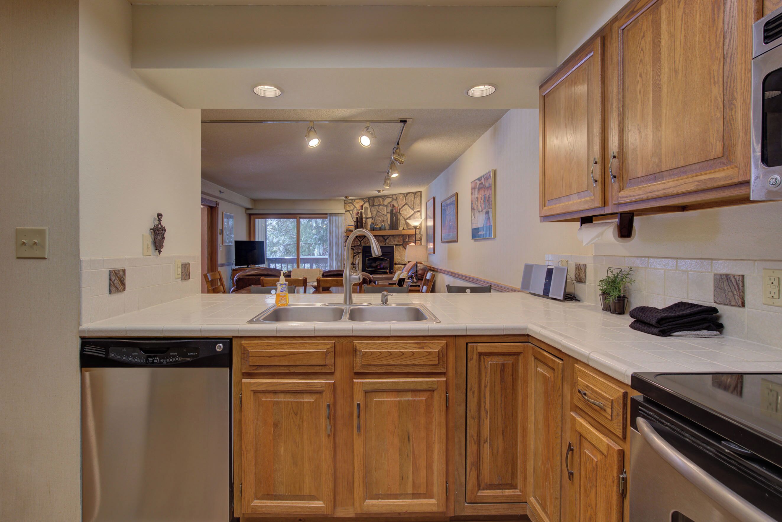 A kitchen with wooden cabinets, a dishwasher, and a stove.