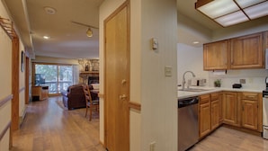 A spacious kitchen with wooden cabinets and a dishwasher. - Atrium 104 Downtown Condos with on-site Hot Tub (Breckenridge)