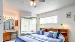 A bedroom with a large bed, a vanity with a mirror, and a shower area. - Casa De Alta Peak 9  Private Home with Hot Tub (Breckenridge)