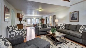 A spacious living room with a high ceiling, a staircase, and a kitchen in the background. - Casa De Alta Peak 9  Private Home with Hot Tub (Breckenridge)