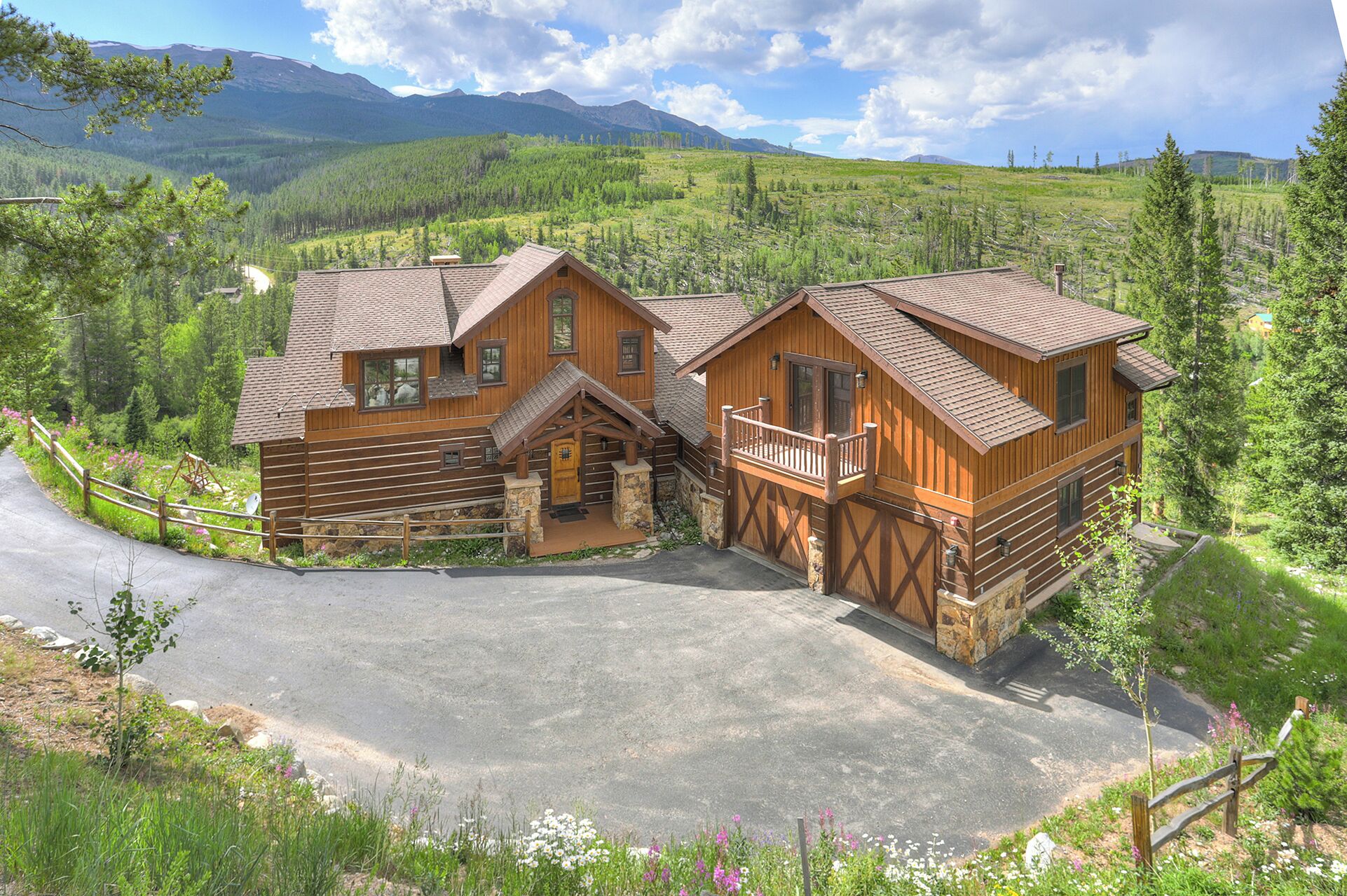 A log cabin with a stone foundation, wooden exterior, and a balcony.