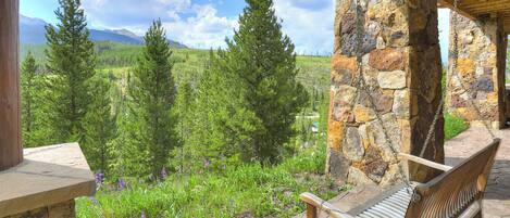 A stone bench with a view of a mountainous landscape.
