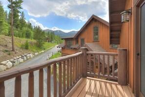 Eine Holzhütte mit einem Balkon mit Blick auf eine Straße und Berge.