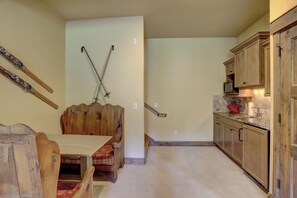 A kitchen with wooden cabinets, a dining table, and a staircase leading to another level. - Cloud Peak Vista Peak 7 Private Home with Hot Tub (Breckenridge)