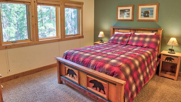A bedroom with a wooden bed, two windows, a green wall, and two framed pictures. - Moose Meadow Retreat Private Home with Hot Tub (Breckenridge)
