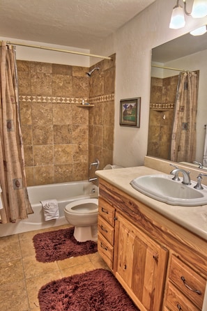 A bathroom with a bathtub, toilet, and sink.