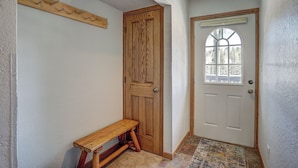 A hallway with a wooden bench, a wooden door, and a window with a view of trees. - Wellington #3 (Townhome with Private Hot Tub) (Breckenridge)