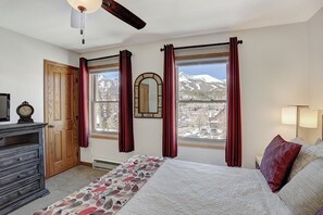 A bedroom with a bed, a dresser, a mirror, and two windows with curtains. - Wellington #3 (Townhome with Private Hot Tub) (Breckenridge)