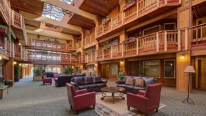 A spacious lobby with multiple levels, wooden balconies, and comfortable seating areas. - Atrium 207 Downtown Condos with on-site Hot Tub (Breckenridge)