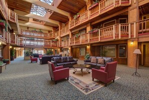 A spacious lobby with multiple levels, wooden balconies, and comfortable seating areas.