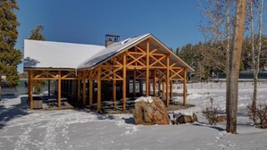 A wooden pavilion with a snow-covered roof, surrounded by snow and trees. - Atrium 207 Downtown Condos with on-site Hot Tub (Breckenridge)