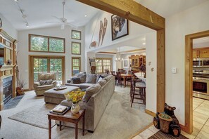 A spacious living room with a fireplace, a dining area, and a kitchen with modern appliances.