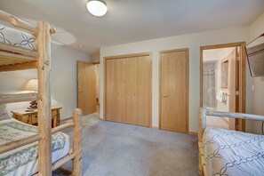 Ein Schlafzimmer mit Etagenbetten, einem Holzschrank und einem Duschbereich.
