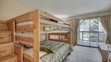A bunk bed room with a sliding glass door leading to a balcony.