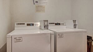 Two Maytag commercial washers with digital displays, a service label, and a wall-mounted instruction sign. - Gold Camp II E87 Condo (Breckenridge)