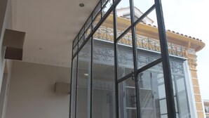 Una esquina de un edificio con un ventanal de vidrio y una barandilla de metal.