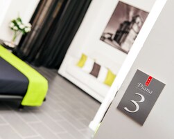 Una habitación de hotel con cama, sofá y un cartel en la pared que indica el número 3.