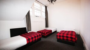 A room with two single beds, a window with curtains, and a chandelier. - Edinburgh Princes Street Top Floor Apt (Edinburgh)