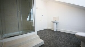 A bathroom with a glass shower enclosure, a white sink, and a toilet. - Edinburgh Princes Street Top Floor Apt (Edinburgh)