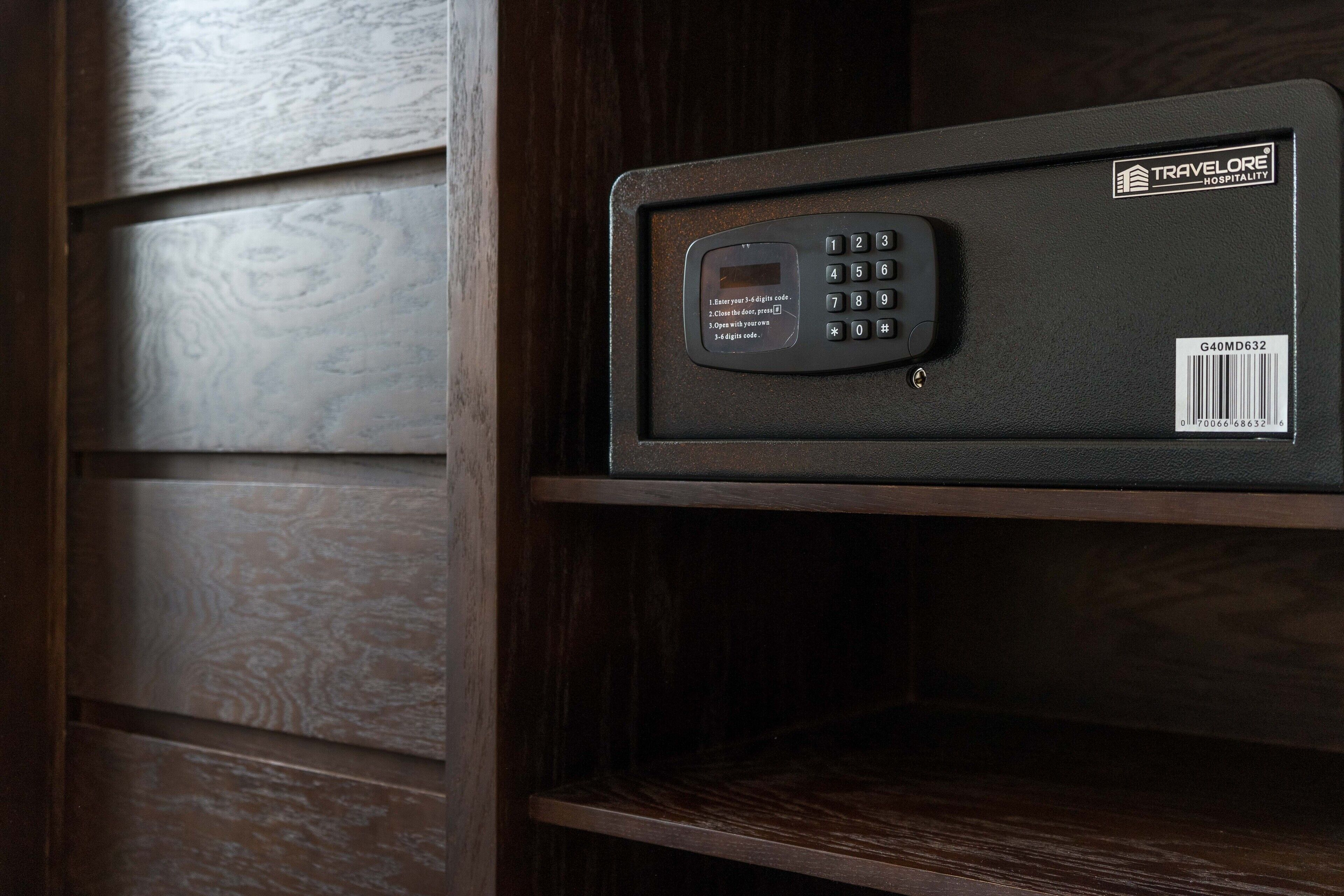 A black electronic device with a keypad and a barcode on a wooden shelf.