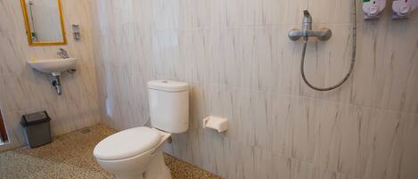 A bathroom with a toilet, sink, and shower.